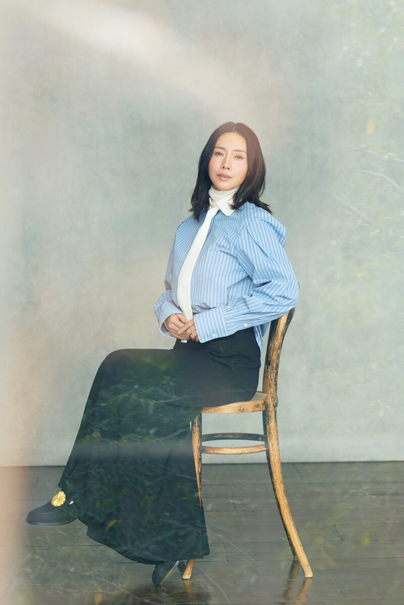 タイ付きシャツ￥88,000／エストネーション、中に着たニット￥39,600 ／コラム（ともにエストネーション）、スカート￥36,300／ロンハーマン、3連リング￥352,000／スピネリキルコリン（リトルリーグ インク）、シューズ￥198,000 ／ジェイエムウエストン（ジェイエムウエストン 青山店）