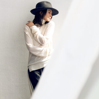 ニット￥83,050、パンツ￥90,750／ともにトーテム（トーテム クライアントサービス）、ハット￥91,300 ／ボルサリーノ（中央帽子）、ピアス￥187,000 ／ベッティーナジャヴァエリ、ネックカフ￥47,300／ロンハーマン（ともにロンハーマン）