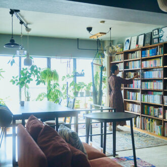 窓一面にグリーン、壁一面に本棚を配した 印象的なリビング・ダイニング