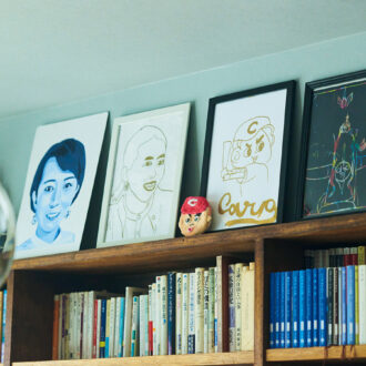 本棚の上には娘たちが描いた岡本さんの肖像画を飾って