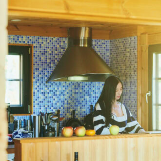 小さな青いタイルのグラデーションが可愛らしい三浦家のキッチン。 旬のリンゴは香りを楽しむためにカウンターに並べて。
