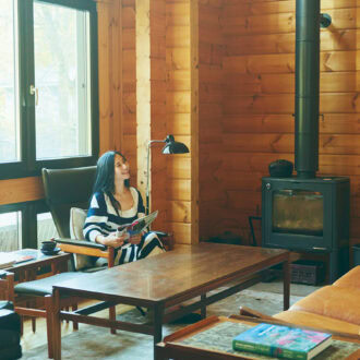 家の中の主役は薪ストーブ。 ログハウスの壁が熱を貯め込むので、換気で窓を開けてもほんわりと暖か。