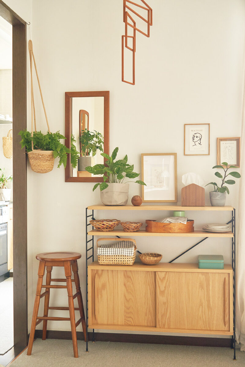リビングのベランダ側の壁にある吸気口やスイッチを隠すため、奥行きが狭いシェルフを購入。「絵やグリーンを置いてカバーし、お茶の道具を飾って見せる収納にしています」。