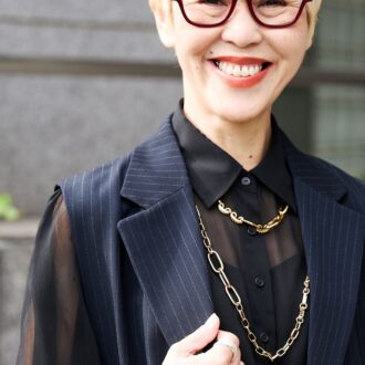 大ぶりのゴールドネックレスで華を添える