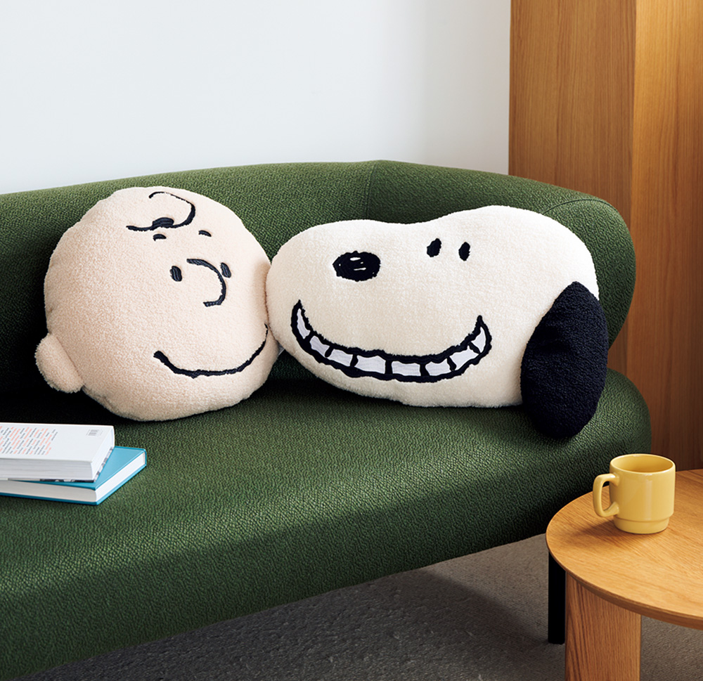 フェイスクッション（右）スヌーピー（縦34×横50×厚み13.5cm）、（左）チャーリー・ブラウン（縦36×横46×厚み14cm）各¥3,900／ともにベイフロー（アダストリア） ※WEB限定販売