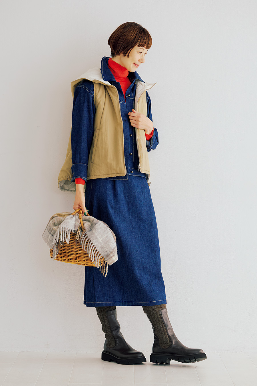 デニムジャケット¥30,800、サスペンダー付きスカート¥28,600／ともにポルテ デ ブトン、フードベスト¥46,200、ブーツ¥71,500／ともにプレインピープル（プレインピープル青山）、タートルネックニット¥2,990／ユニクロ、カゴ¥14,300／ハリス（金万）、カゴに入れたストール¥10,780／ツイードミル（セムインターナショナル）