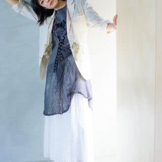 ジャケット￥97,900／ミラ ショーン バイ チカ キサダ（コロネット）、Tシャツ￥132,000／チカ キサダ、スカート￥130,900 ／ドゥロワー（ドゥロワー 青山店）、フローラルモチーフネックレス￥13,200／マージ（エスアンドティ）、ロングネックレス￥47,300 ／フローリアン、イヤカフ右耳￥9,900、ピンクのブレスレット￥34,100、ブルーのブレスレット￥36,300／すべてジェム・キングダム（すべてアッシュ・ペー・フランス）、シューズ￥59,400 ／ペリーコ（アマン）