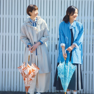 （右）ジャケット¥35,200／エフシーイー®️（エフシーイーフラッグシップストアトウキョウ）、ノースリーブワンピース¥58,300／デ・ドゥエ（アッシュ・ペー・フランス）、シャツ¥40,700／コンテンポ（ヤエカ ホーム ストア）、スニーカー¥26,400／クレイ（リーガルコーポレーション）、傘¥19,800／マニプリ （左）コート¥75,900／パドカレ（パドカレ六本木）、シャツ¥41,800／プレインピープル（プレインピープル青山）、パンツ¥23,100／ロワズィール、スニーカー¥22,000／ホカ®️（デッカーズジャパン）、傘¥19,800／マニプリ