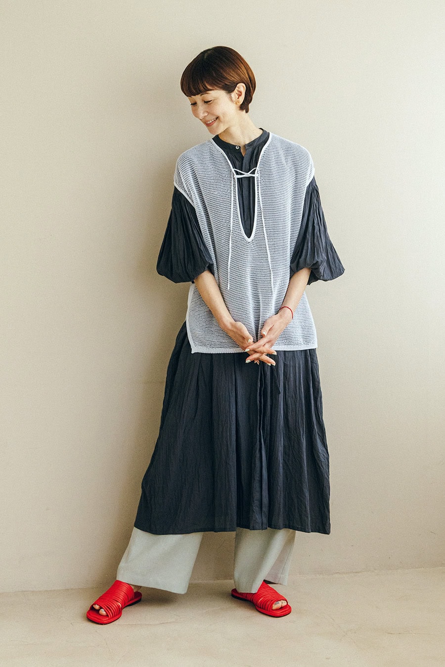 レースエプロン¥52,800／エリテ（ケイエムディーファーム）、タンクトップ¥7,040、サンダル¥19,800／ともにロワズィール、カゴバッグ¥15,400／ケッシュ ル エッセンシャル（ザエディット ストア）